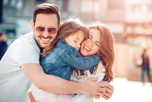 Happy young family in city street